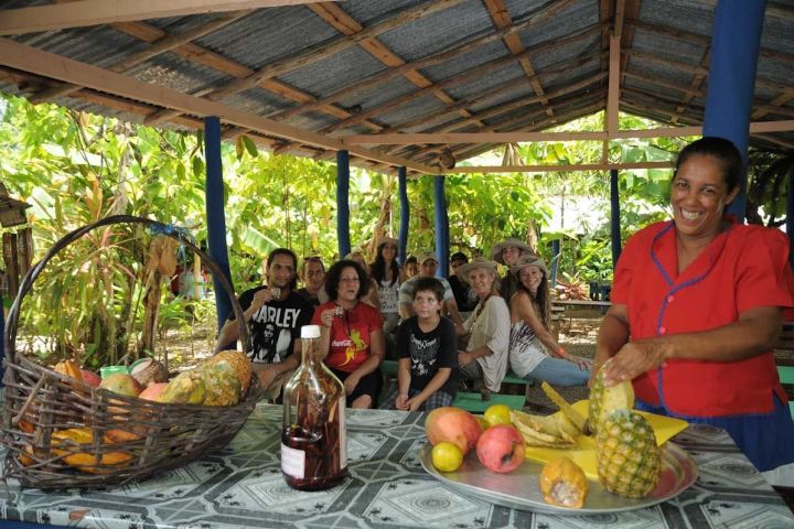 a group of people sitting at a fruit stand