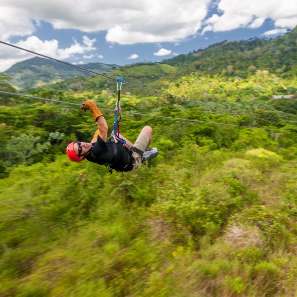 a person in a swing with a mountain in the background