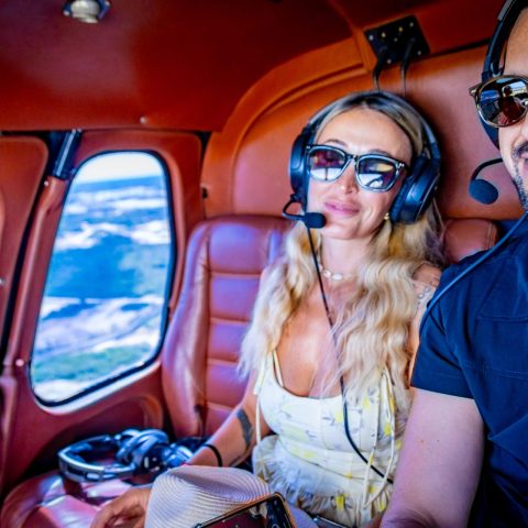Man and woman in sunglasses upside down in a small aircraft cabin.