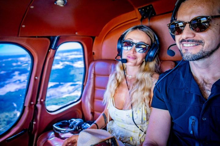 Man and woman in sunglasses upside down in a small aircraft cabin.