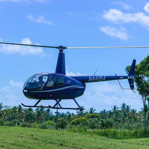 a helicopter flying over a field