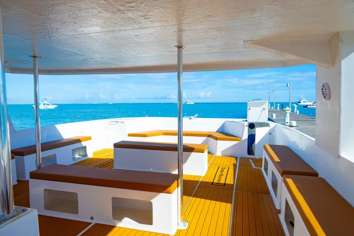 Interior of a boat with benches and calm sea view from the deck.