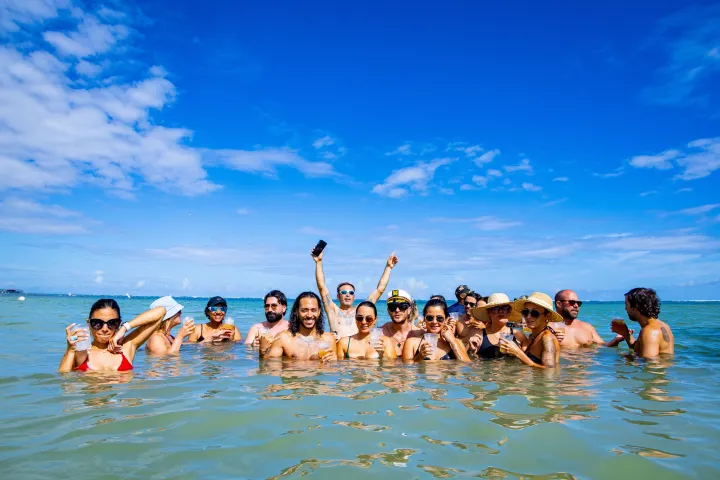 Group of people having fun in the ocean under a clear blue sky.